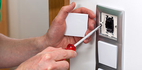 An electrician installing new light switches for a home renovation project