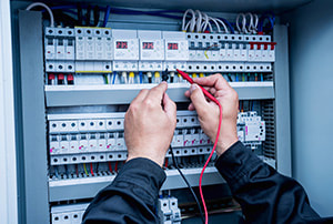 Electrical safety check being performed testing a switchboard with a voltmeter