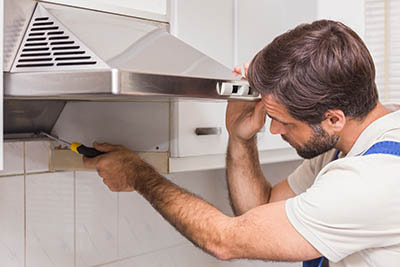 Electrician installing kitchen electrical appliance
