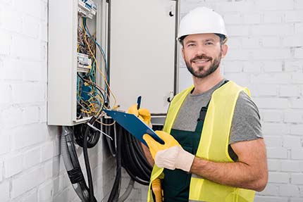 Ballarat electrician standing next to switchboard with checklist