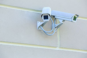 Two security cameras installed on a wall of a commercial building